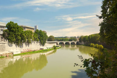 Arch bridge over river against sky