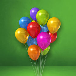 Close-up of multi colored balloons against green background