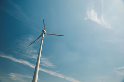 Low angle view of wind turbine against blue sky