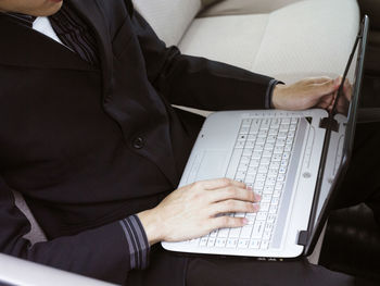 High angle view of businessman using laptop while sitting on seat