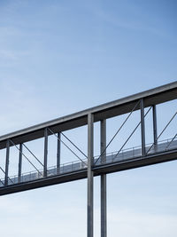 Low angle view of concrete foot bridge against sky