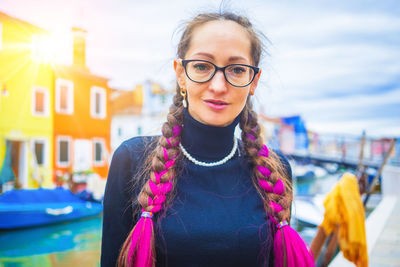 Portrait of smiling young woman wearing sunglasses against sky