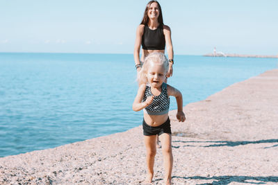 Happy mother and daughter on pier