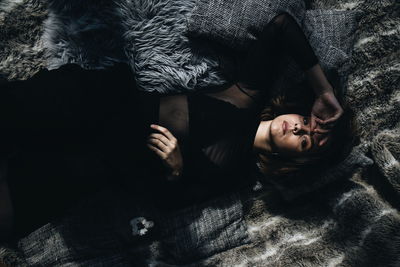 Portrait of young woman lying on bed