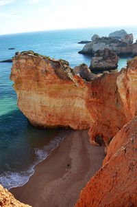 Rock formation on beach against sky