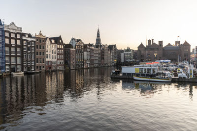 Boats in river with buildings in background