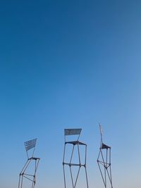 Low angle view of windmill against clear blue sky