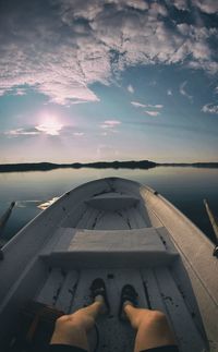 Low section of man relaxing in boat on lake