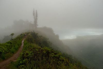 Scenic view of landscape against sky during foggy weather