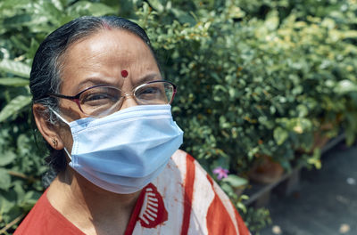 Portrait of an aged indian woman wearing surgical face mask due to covid-19 pandemic.