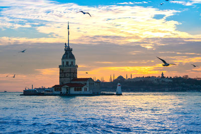 View of building at waterfront during sunset