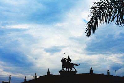 Low angle view of silhouette statue against sky