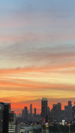 Modern buildings against sky during sunset