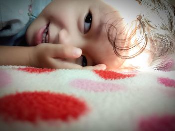 Close-up of girl smiling while lying on bed