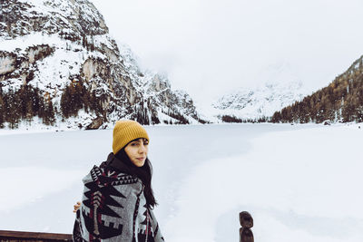 Portrait of woman sitting against snow covered land