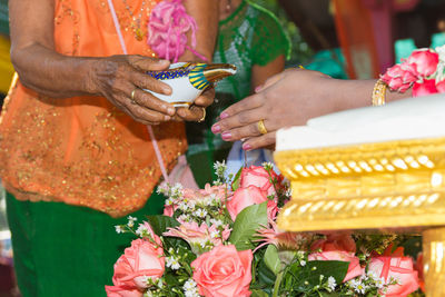 Midsection of woman holding bouquet