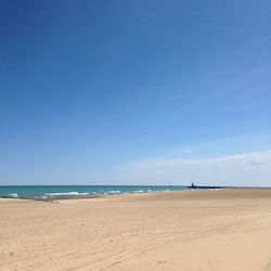 Scenic view of beach against blue sky