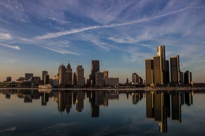 Reflection of buildings in river against sky