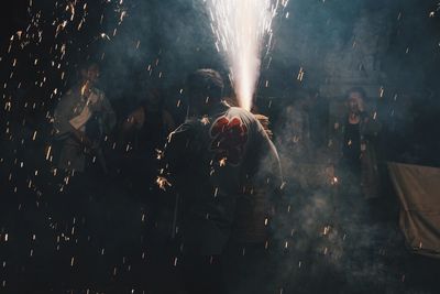 People watching firework display at night
