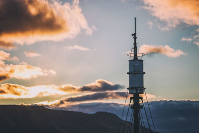 Low angle view of communications tower against sky during sunset