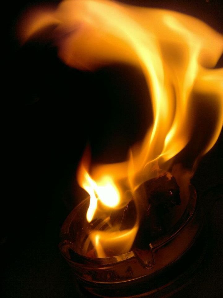 CLOSE-UP OF LIT CANDLE IN DARKROOM