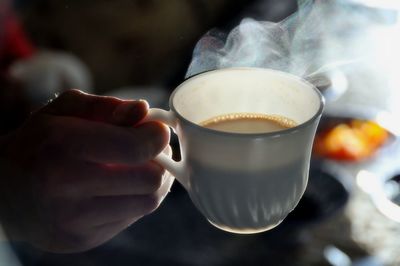Cropped image of person holding hot coffee