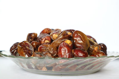 Close-up of fruits in plate against white background