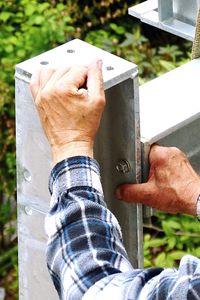 Cropped hand of man fixing metal structure