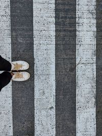 Low section of person standing on cobblestone street