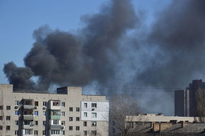 There is black smoke from a rocket or bomb explosion in a city during a war