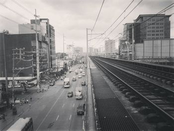 Railroad tracks in city against sky