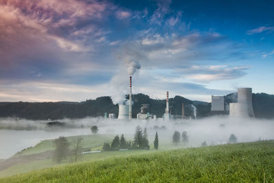 Factory in foggy weather against blue sky