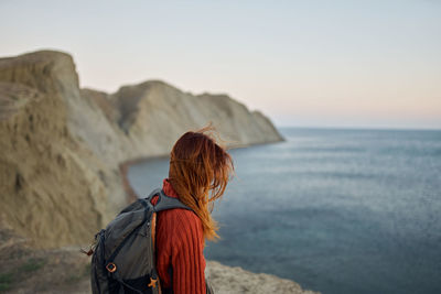 Rear view of woman looking at sea against sky