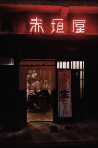 Text on illuminated store at night