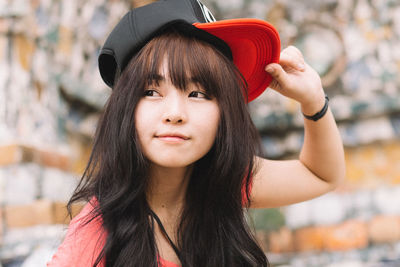 Portrait of young woman wearing hat standing outdoors