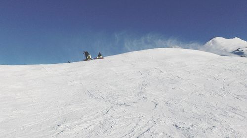 People skiing on snowcapped mountain against sky