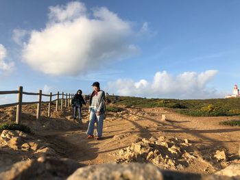 Full length of men walking on land against sky