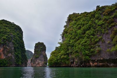 Scenic view of rocks by sea against sky