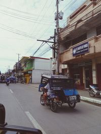 Cars on road against sky in city