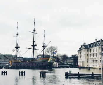 Boats moored at harbor against sky