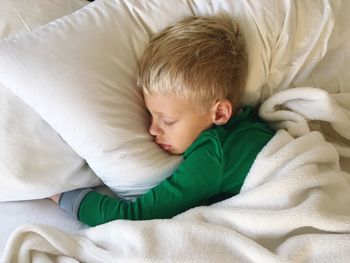 High angle view of boy sleeping on bed