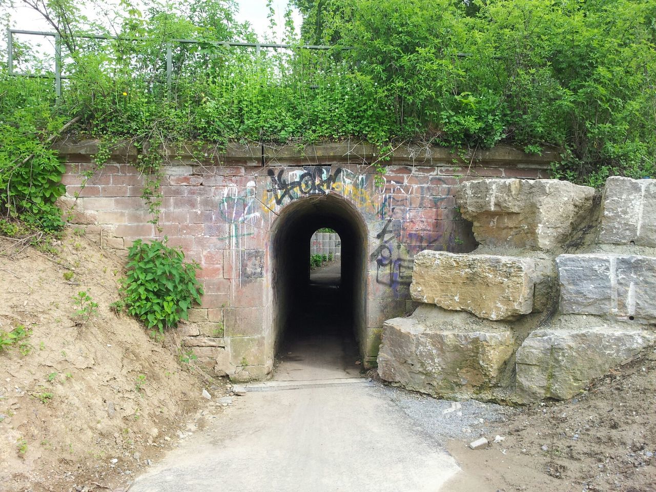 architecture, built structure, the way forward, arch, archway, plant, stone wall, entrance, building exterior, tree, diminishing perspective, wall - building feature, empty, wall, day, leading, old, walkway, footpath, door