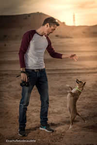 Full length of man standing with dog on land