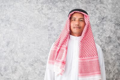 Portrait of man wearing kaffiyeh against wall