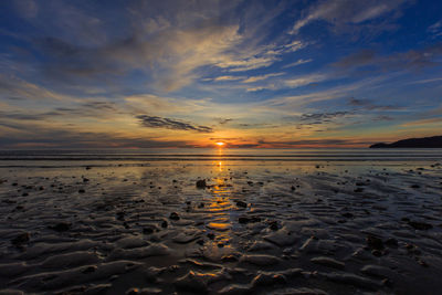 Scenic view of beach against sky during sunset