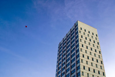 Low angle view of modern buildings against blue sky