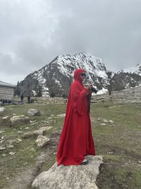 Rear view of woman standing on mountain against sky