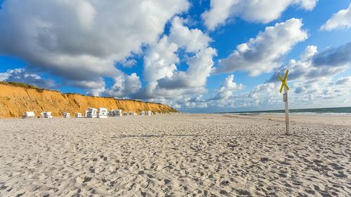 Scenic view of beach against cloudy sky