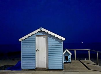 Built structure on beach by sea against sky at night