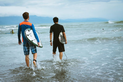 Surfers walking in sea